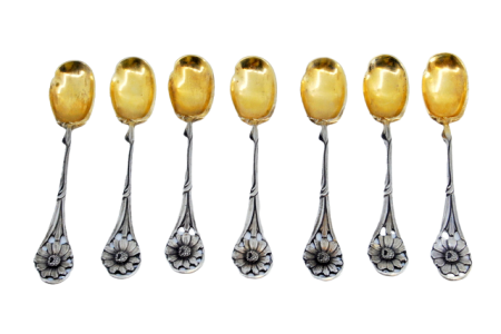 Conjunto de sete colheres em prata com relevo de flor da pega e concha dourada